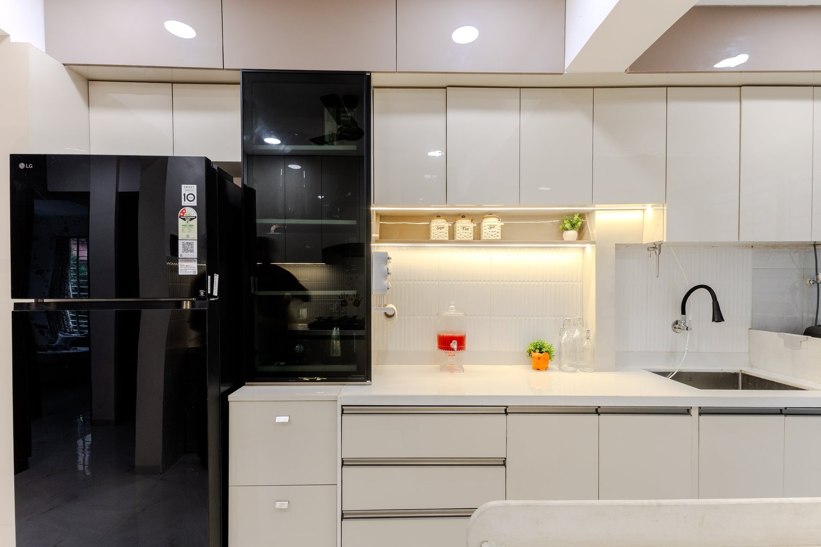 Modern modular kitchen with glass cabinet and appliances by Design DNA