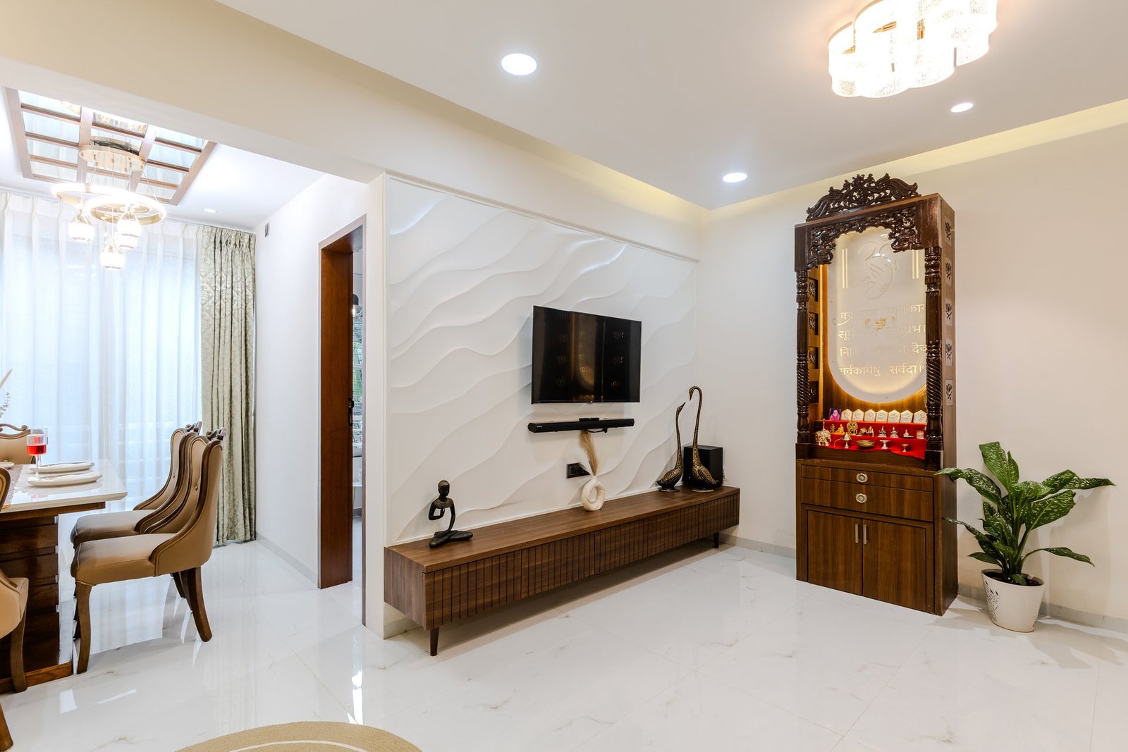 Living room with handcrafted wooden pooja mandir by Design DNA