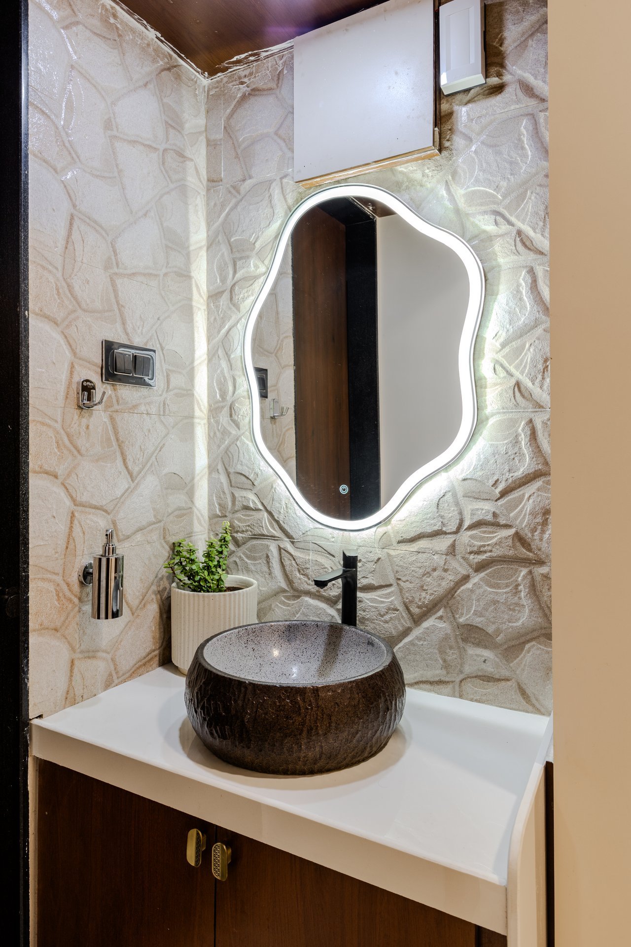 Luxury vanity with carved stone basin and wavy backlit mirror by Design DNA